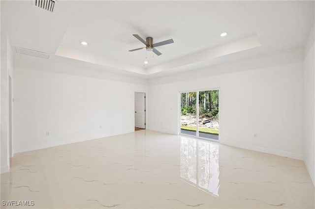 unfurnished room with a raised ceiling and ceiling fan