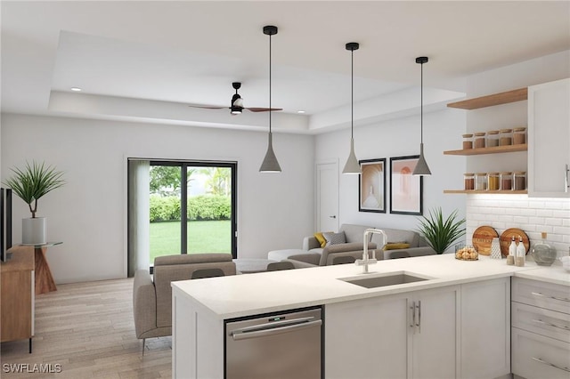 kitchen featuring light hardwood / wood-style floors, white cabinetry, sink, and a tray ceiling