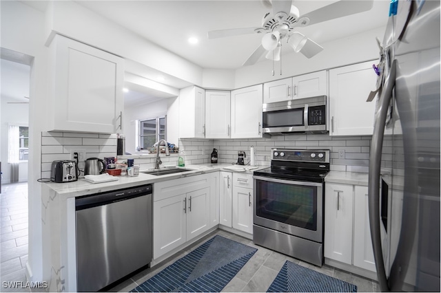 kitchen featuring appliances with stainless steel finishes, white cabinetry, and sink