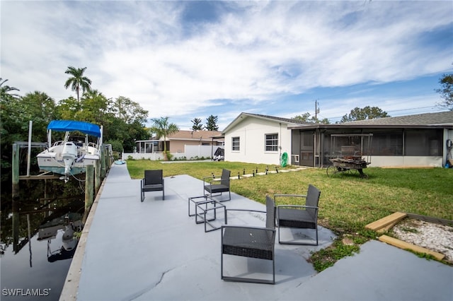 view of patio / terrace featuring a dock and a sunroom