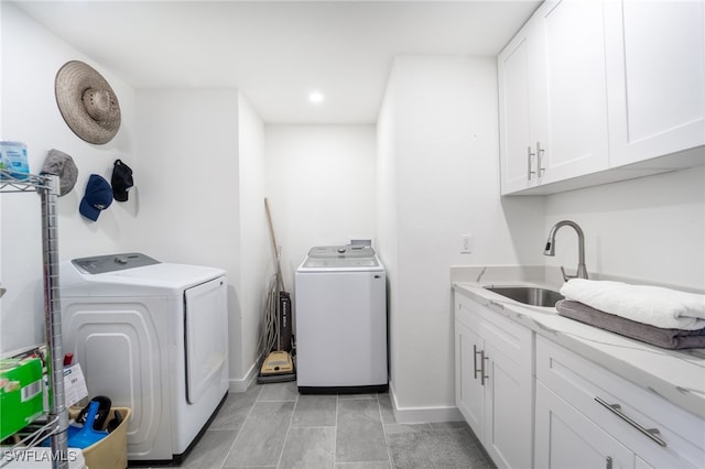 laundry room featuring cabinets, sink, and washing machine and clothes dryer