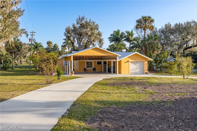 view of front facade featuring a garage, concrete driveway, and a front yard