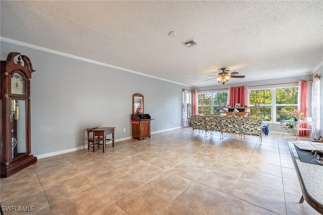 living area with light tile patterned flooring, a ceiling fan, visible vents, and ornamental molding