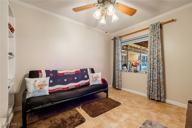 living area with baseboards, ceiling fan, tile patterned flooring, a textured ceiling, and crown molding