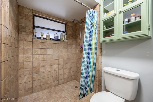 bathroom with toilet and a tile shower