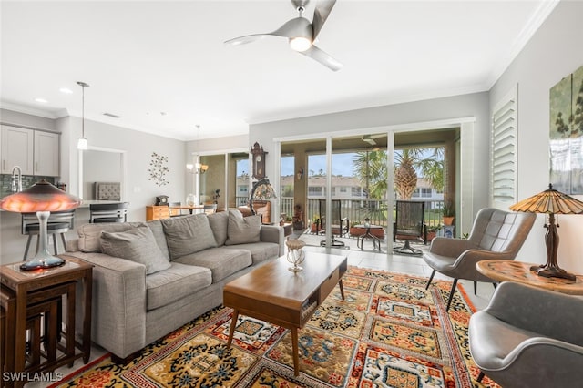 living room featuring ceiling fan with notable chandelier, light tile patterned floors, and crown molding