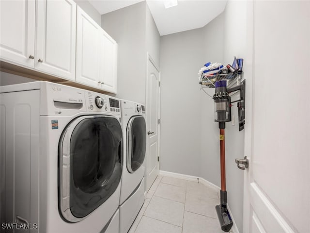 clothes washing area with cabinets, separate washer and dryer, and light tile patterned flooring