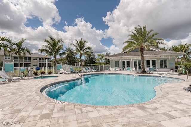 view of pool with a patio area and a community hot tub