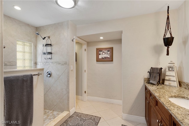 bathroom with tile patterned floors, vanity, and a tile shower