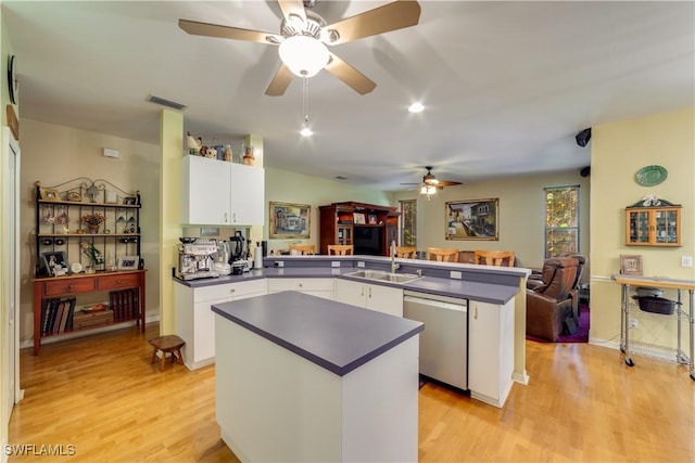 kitchen with kitchen peninsula, sink, dishwasher, light hardwood / wood-style floors, and white cabinetry