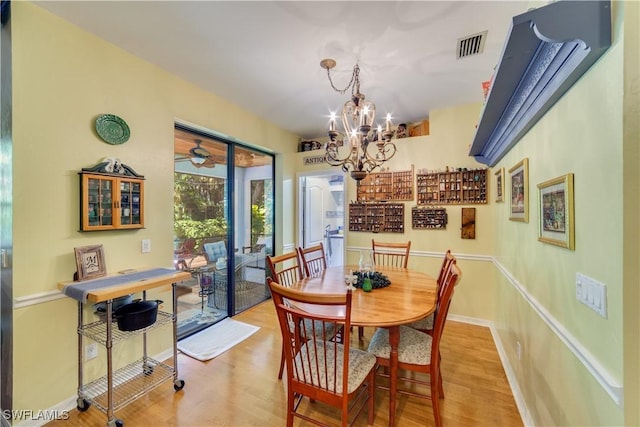 dining space featuring light wood-type flooring and a chandelier