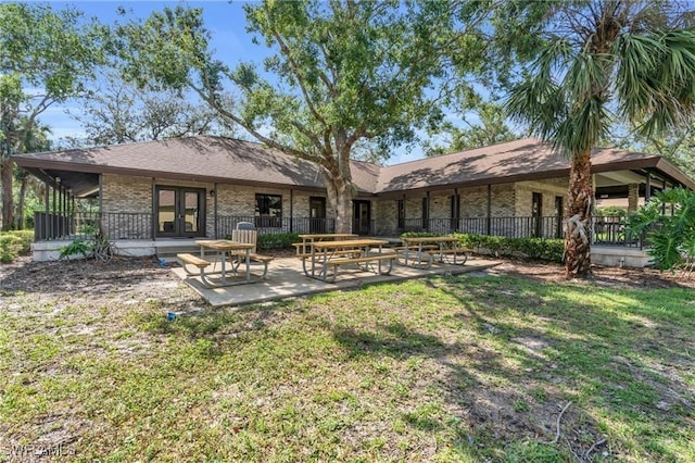 back of house with french doors, a patio, and a lawn