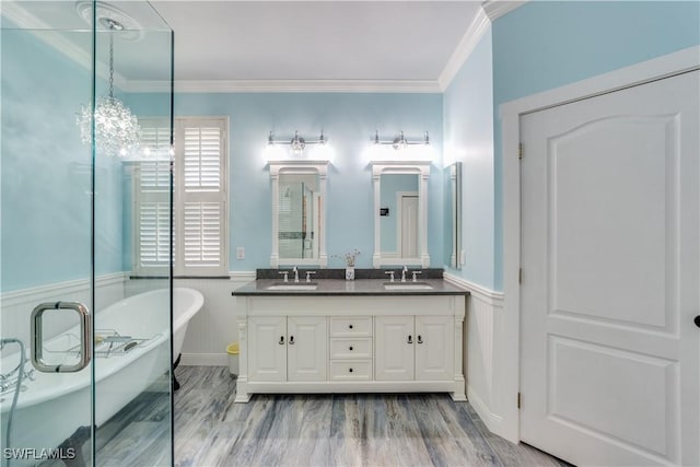 bathroom with hardwood / wood-style flooring, a bathtub, crown molding, and vanity