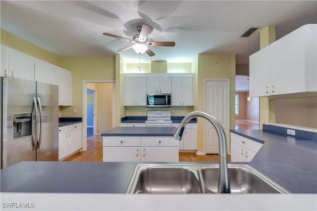 5960 Grey Fox Run, Fort Myers, FL 33912 - kitchen with stainless steel appliances, ceiling fan, dark countertops, and light wood finished floors