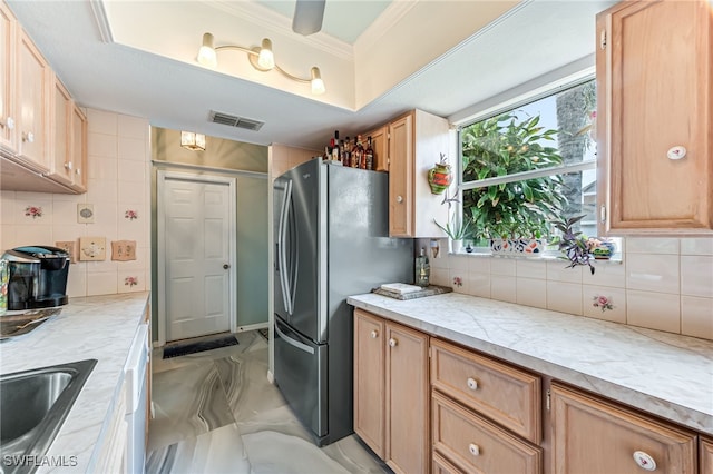 kitchen with backsplash, stainless steel fridge, sink, and light stone counters