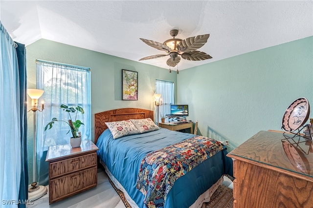 bedroom featuring a textured ceiling, ceiling fan, and lofted ceiling