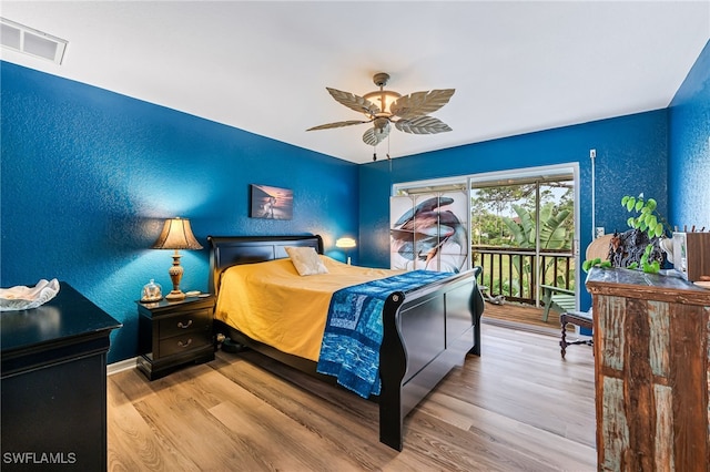 bedroom featuring hardwood / wood-style floors, ceiling fan, and access to outside