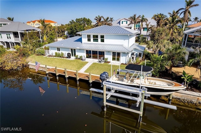 rear view of house with a water view and a yard