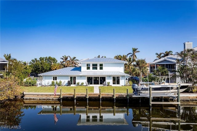 rear view of property with a lawn and a water view