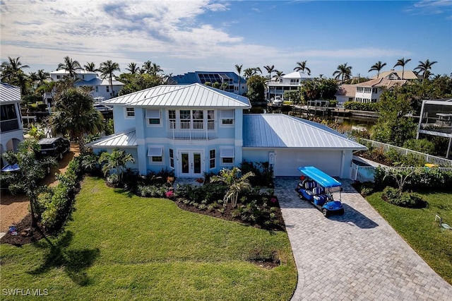 exterior space featuring a water view, a yard, and french doors