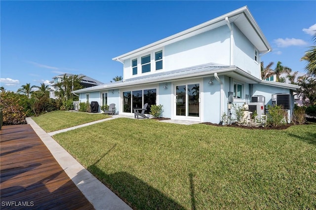 rear view of property featuring a lawn