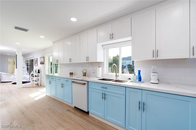 kitchen featuring decorative backsplash, white cabinetry, light stone countertops, and sink