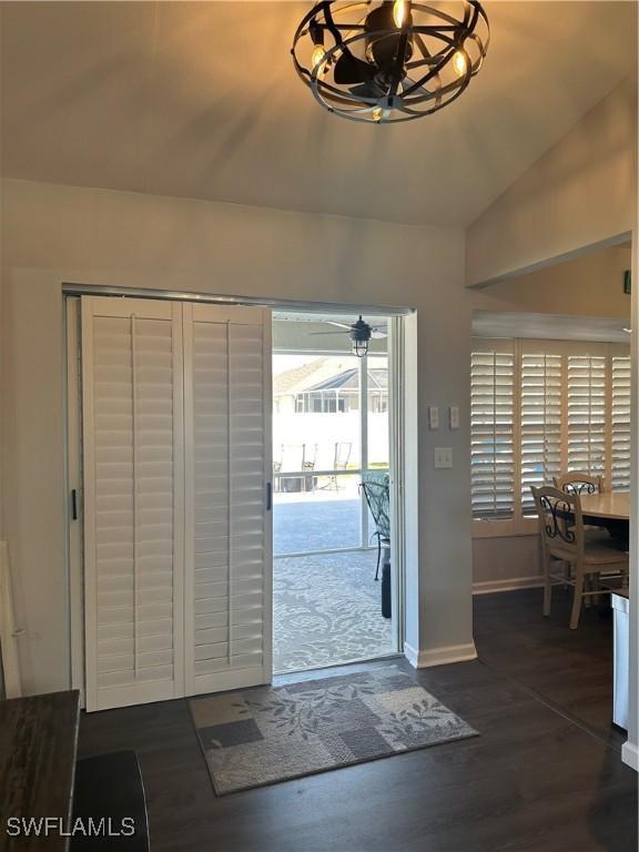 doorway to outside featuring a chandelier, dark hardwood / wood-style floors, and lofted ceiling