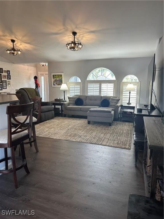 living room with dark wood-type flooring and a chandelier