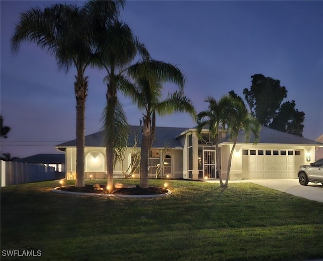 view of front facade featuring a garage and a yard