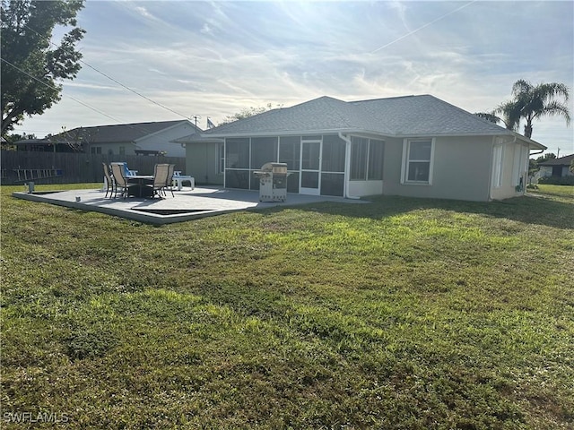 back of property with a yard, a patio area, and a sunroom