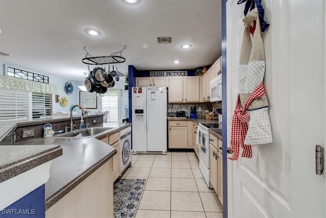 kitchen with light brown cabinets, sink, a chandelier, white appliances, and washer / dryer