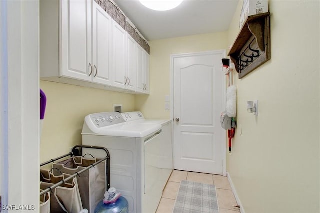 washroom with independent washer and dryer, cabinets, and light tile patterned floors