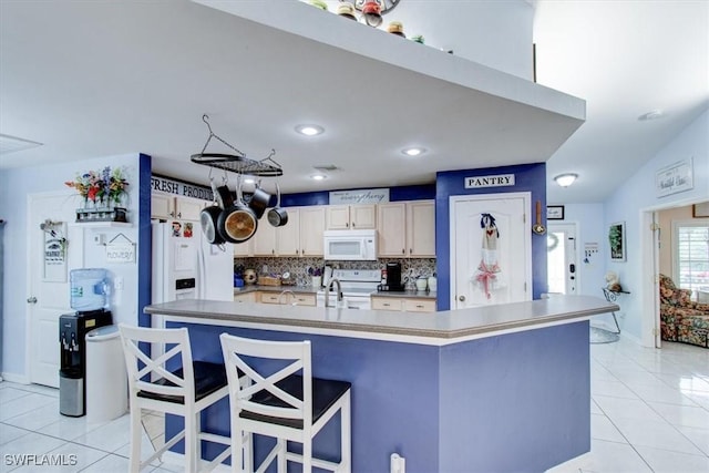 kitchen featuring white appliances, backsplash, a kitchen breakfast bar, a spacious island, and light tile patterned floors