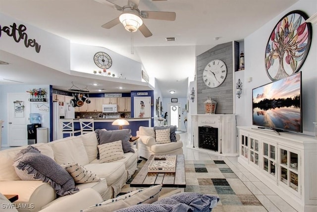 living room with light tile patterned floors, vaulted ceiling, and ceiling fan