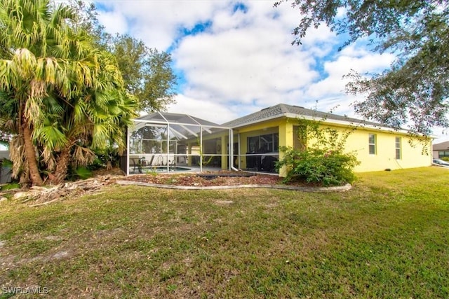 back of house with a lawn and a lanai