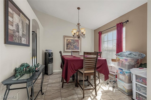 dining space with vaulted ceiling and an inviting chandelier