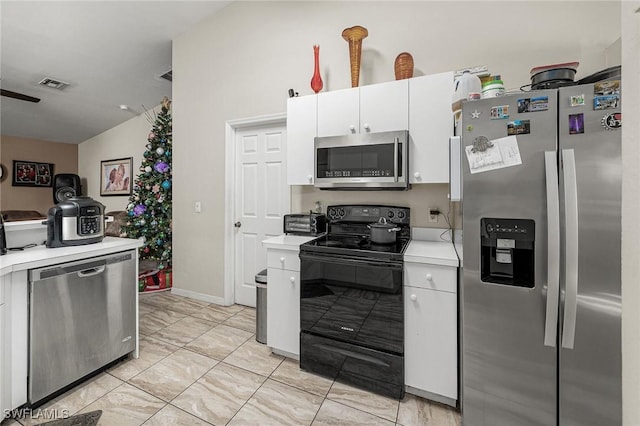 kitchen featuring appliances with stainless steel finishes, vaulted ceiling, and white cabinetry