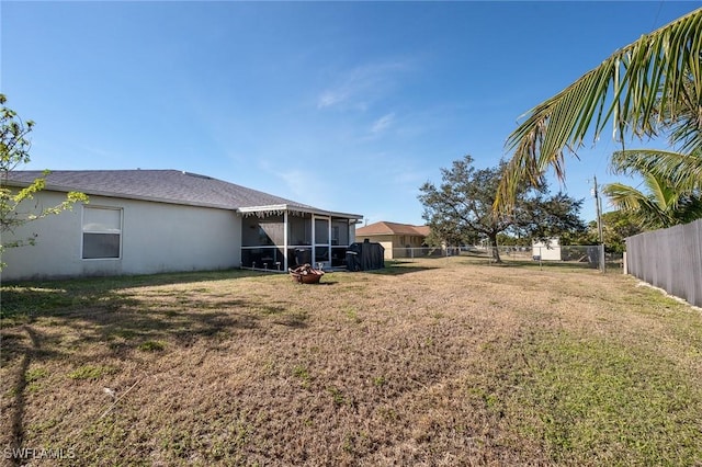 view of yard featuring fence and a sunroom