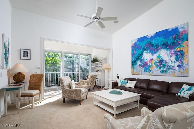 carpeted living room with ceiling fan and high vaulted ceiling