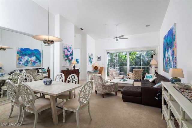 dining room featuring light carpet, high vaulted ceiling, and ceiling fan