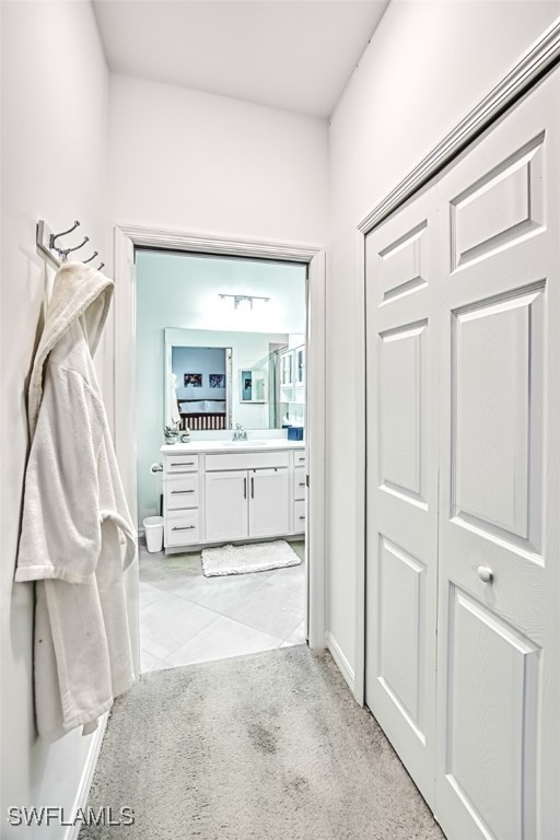 corridor with light colored carpet and sink