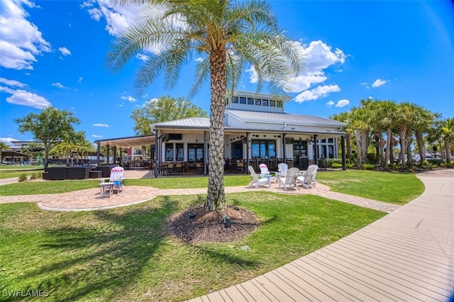 rear view of house featuring a lawn, an outdoor fire pit, and a patio