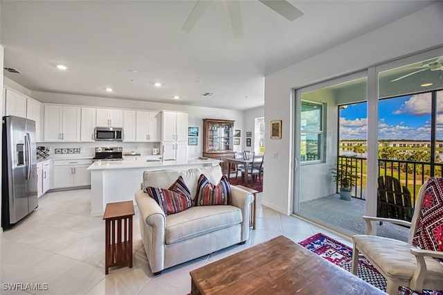 tiled living room with ceiling fan and sink