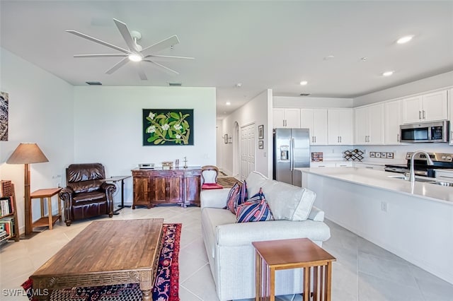 living room with sink, ceiling fan, and light tile patterned flooring