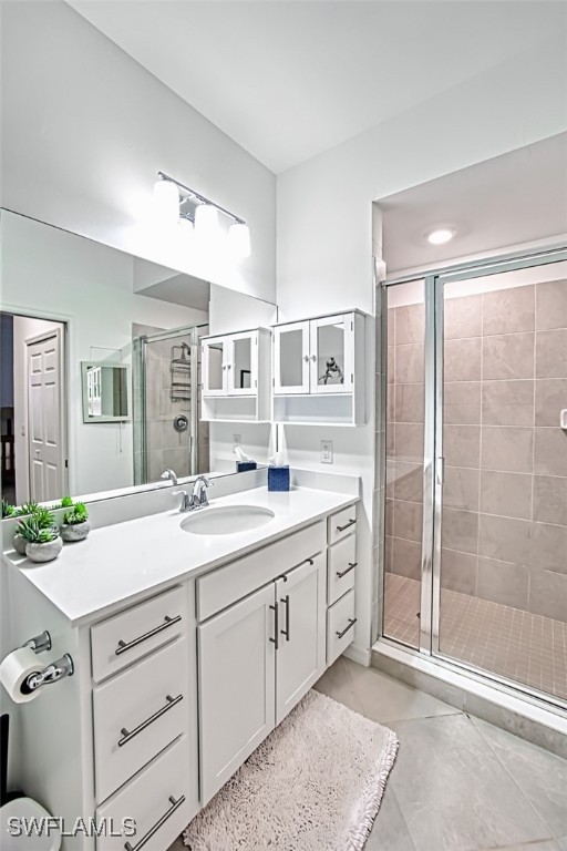 bathroom with tile patterned flooring, vanity, and a shower with shower door