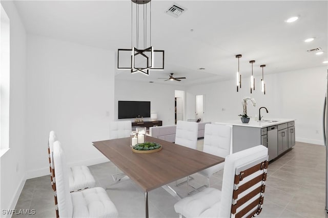 tiled dining space with ceiling fan and sink