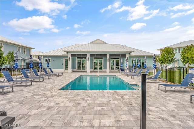 view of swimming pool featuring a patio and french doors