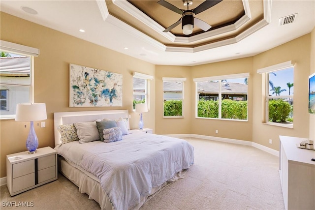 carpeted bedroom with a raised ceiling, ceiling fan, and ornamental molding