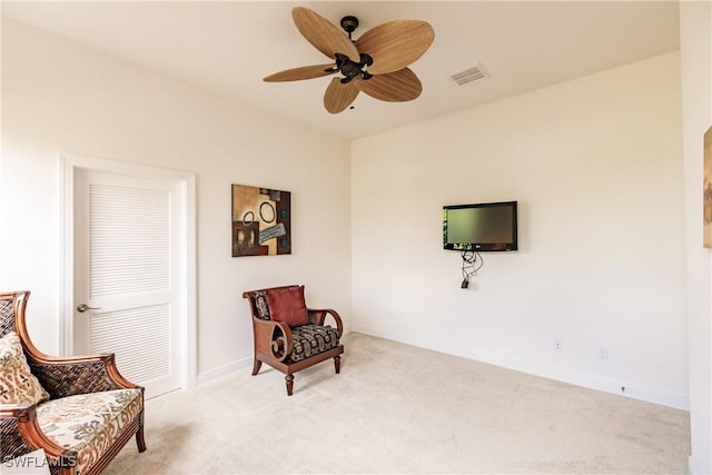 living area with light carpet and ceiling fan