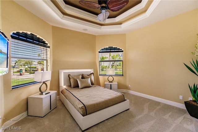 bedroom featuring ceiling fan, a raised ceiling, light carpet, and crown molding